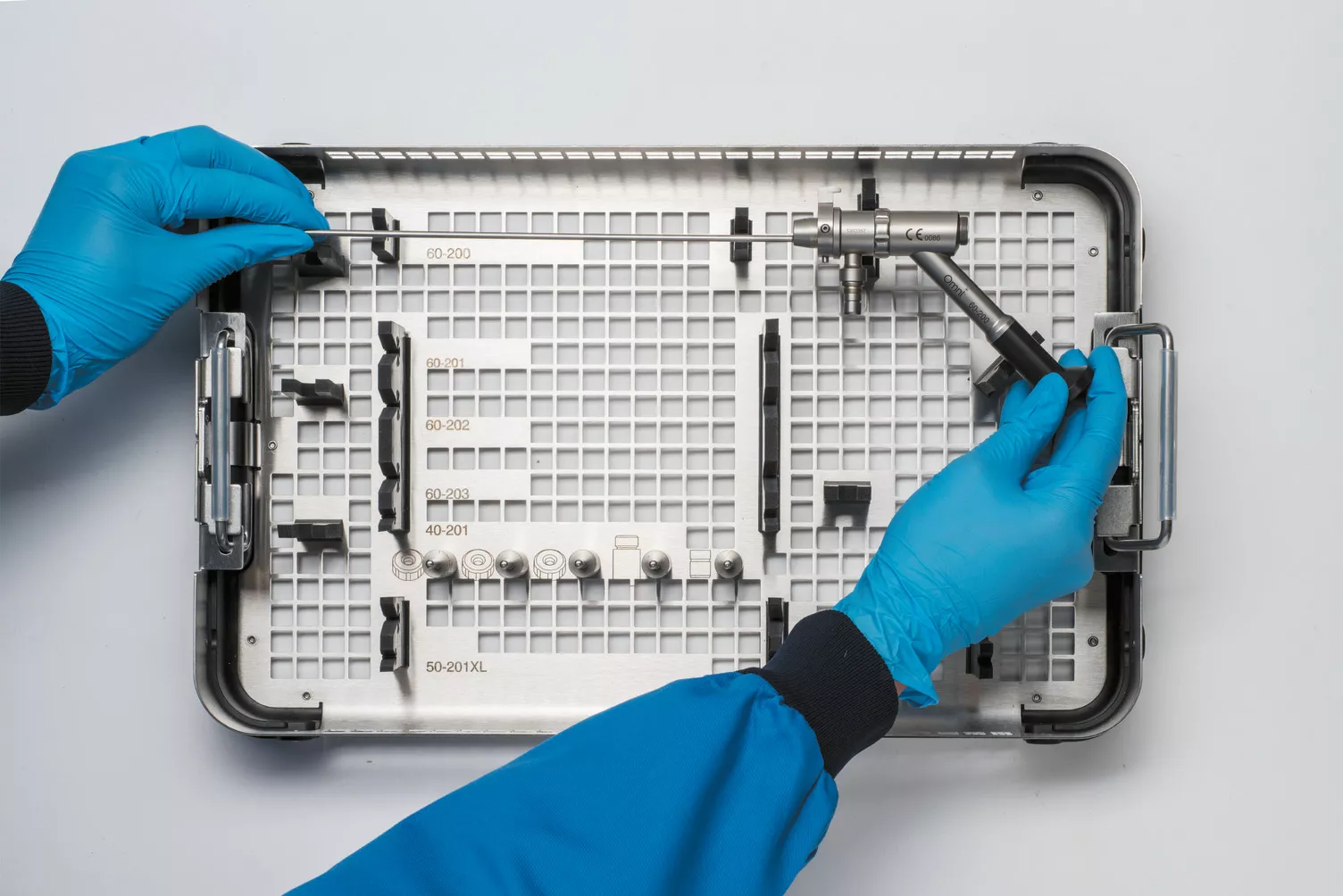 Gloved hands working medical tray on table.